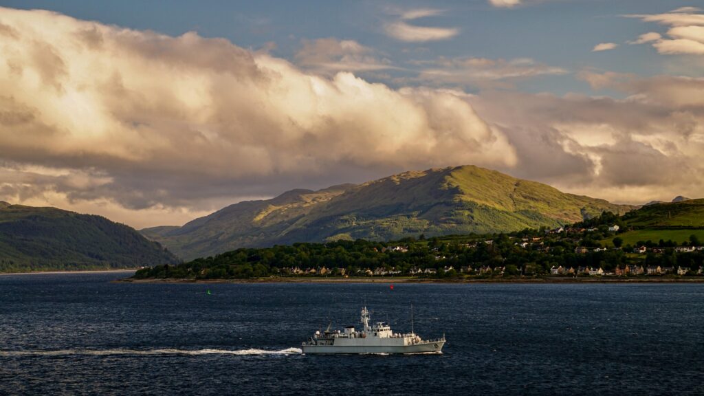 A scenic view of Gourock, Scotland featuring a ferry on a sunny day.