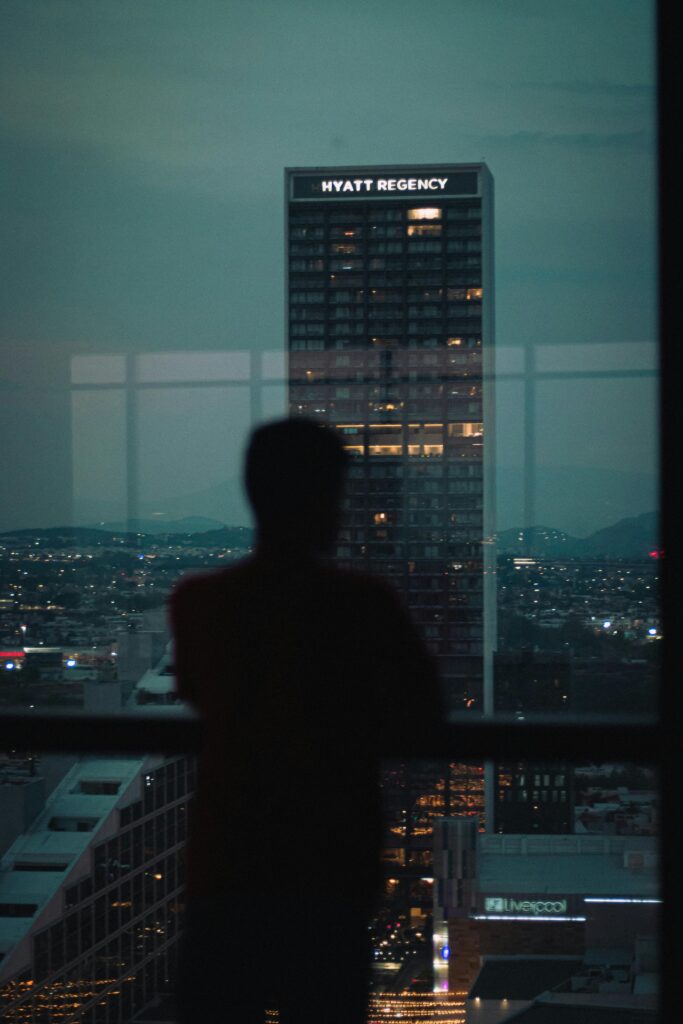 Silhouette of a Person Looking through a Window