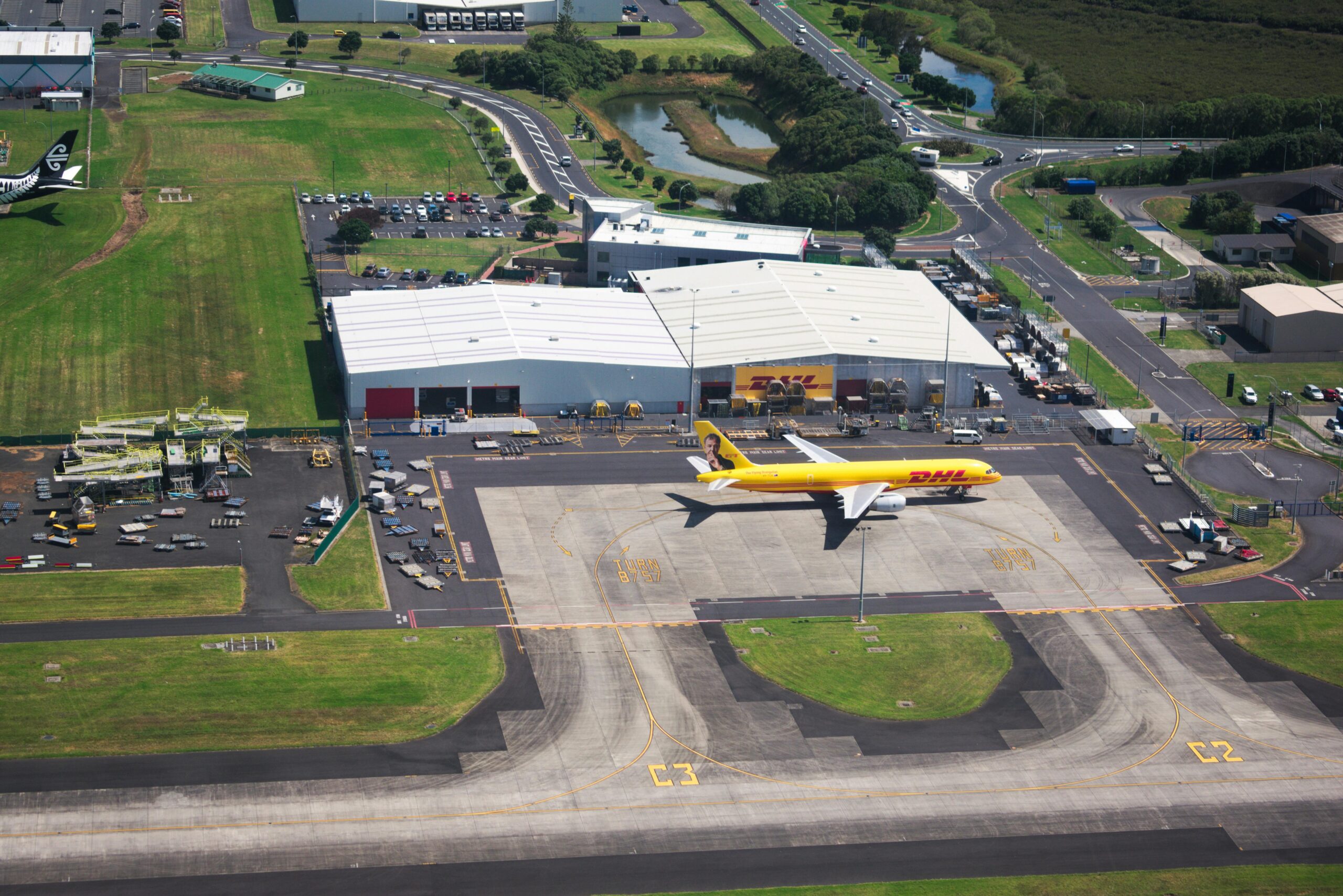 A Commercial Airplane Parked near a Hangar