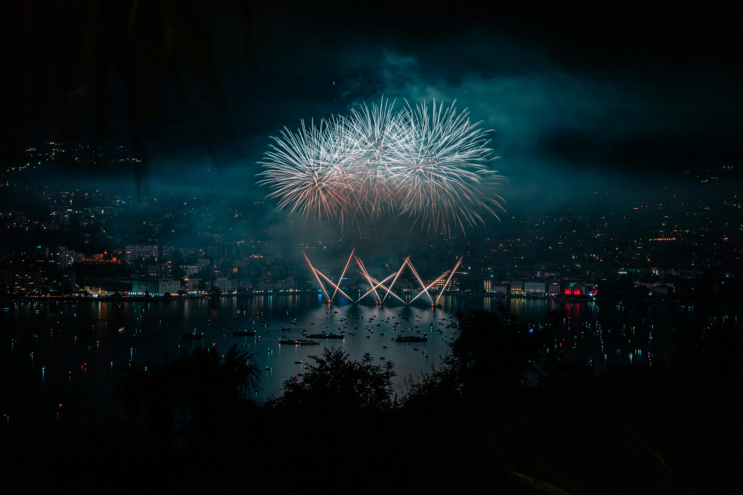 Stunning fireworks display illuminates the night sky over Lugano Lake, Switzerland.