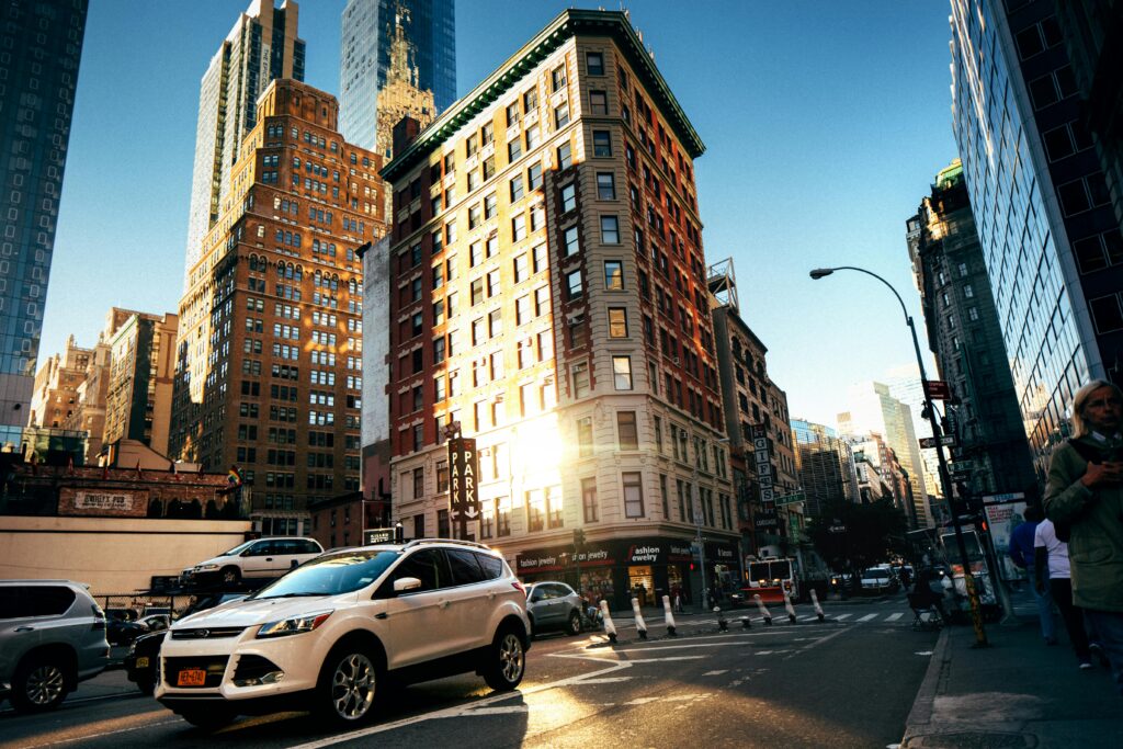 A bustling New York City street with towering buildings at golden hour, capturing urban life.