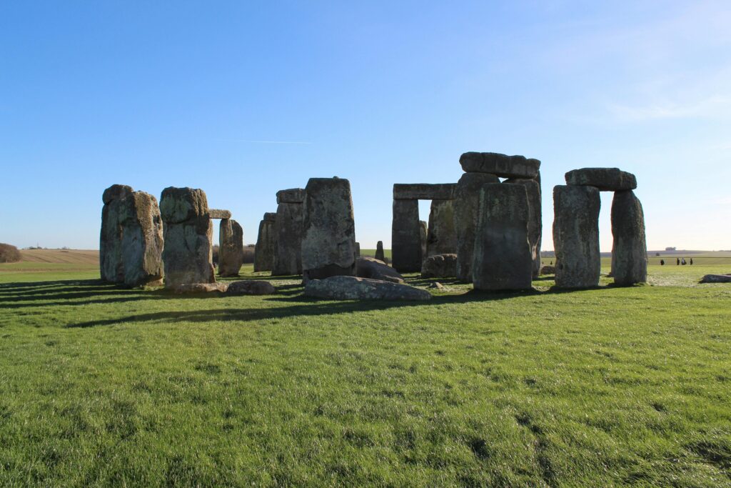 A stunning view of Stonehenge's megalithic stones on a sunny day with clear blue skies.