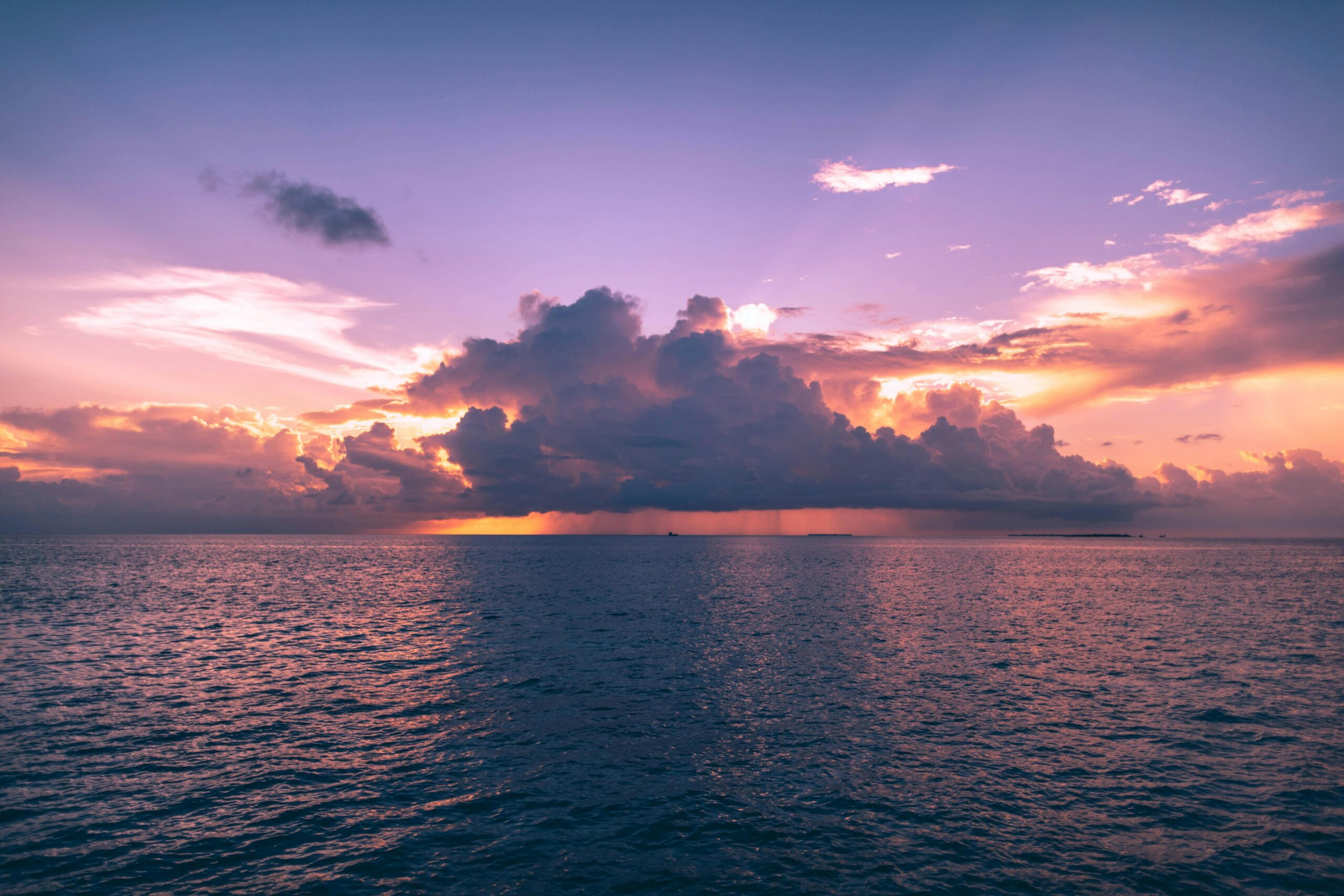 Stunning sunset view with dramatic clouds over the ocean in Maldives, perfect for travel inspiration.