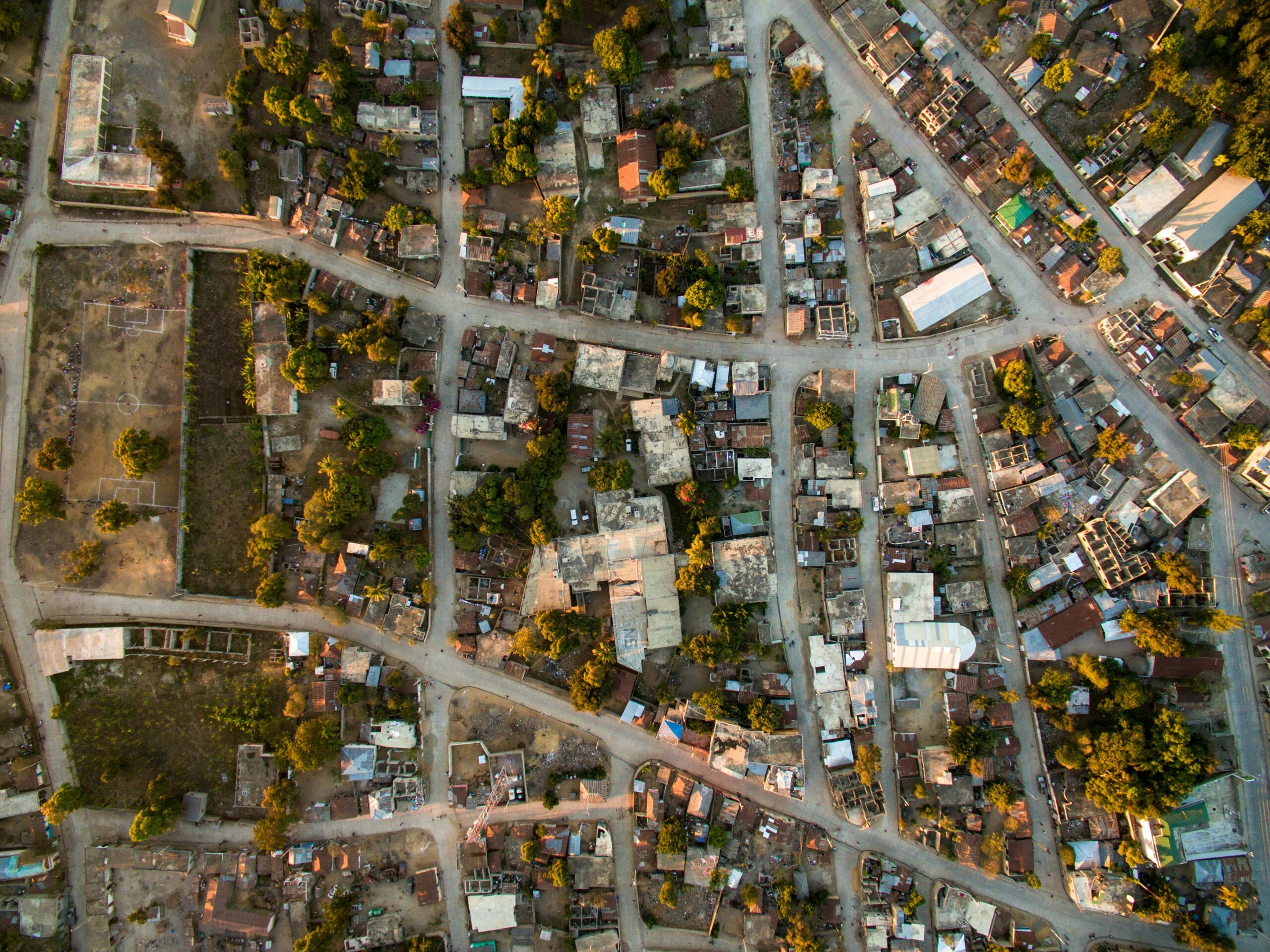 A high-angle aerial view of a bustling urban neighborhood in Haiti, showcasing roads and buildings.