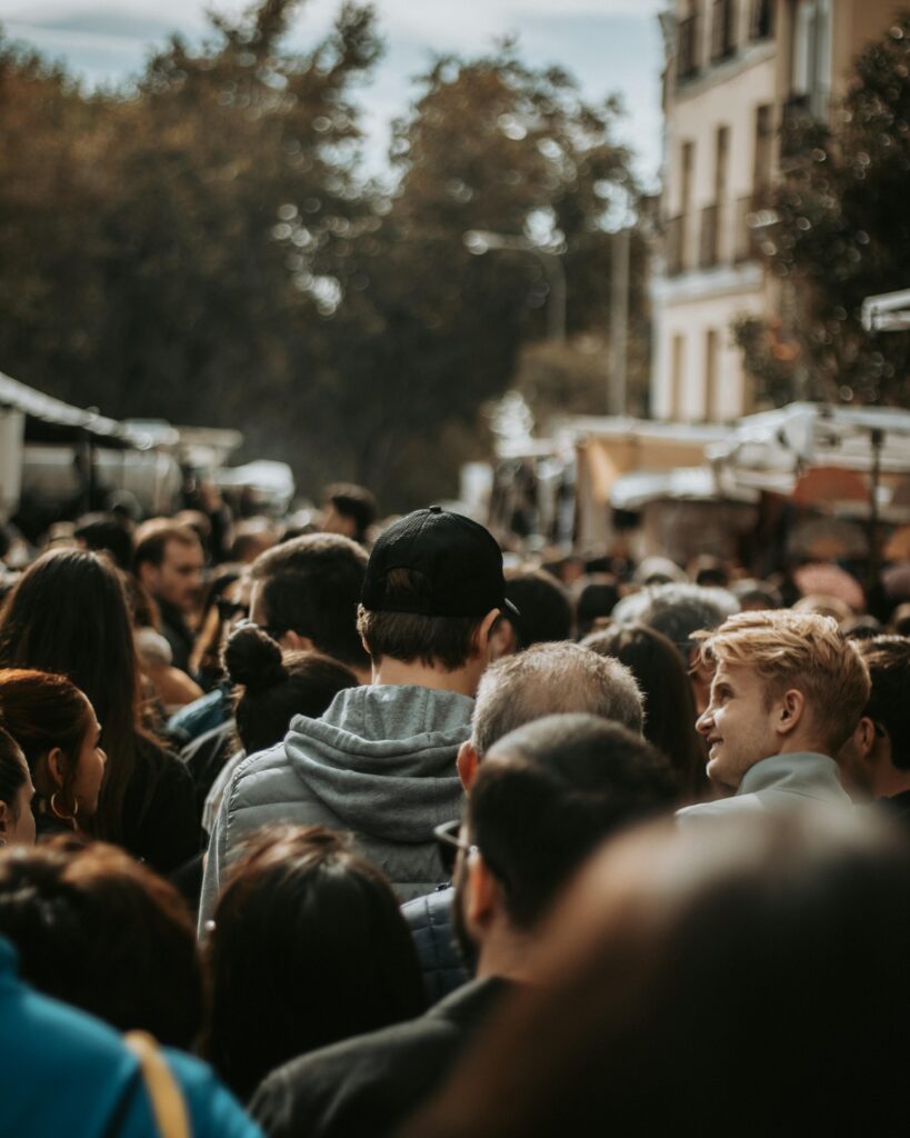 Busy street market scene with a crowd of diverse individuals in Madrid, Spain.