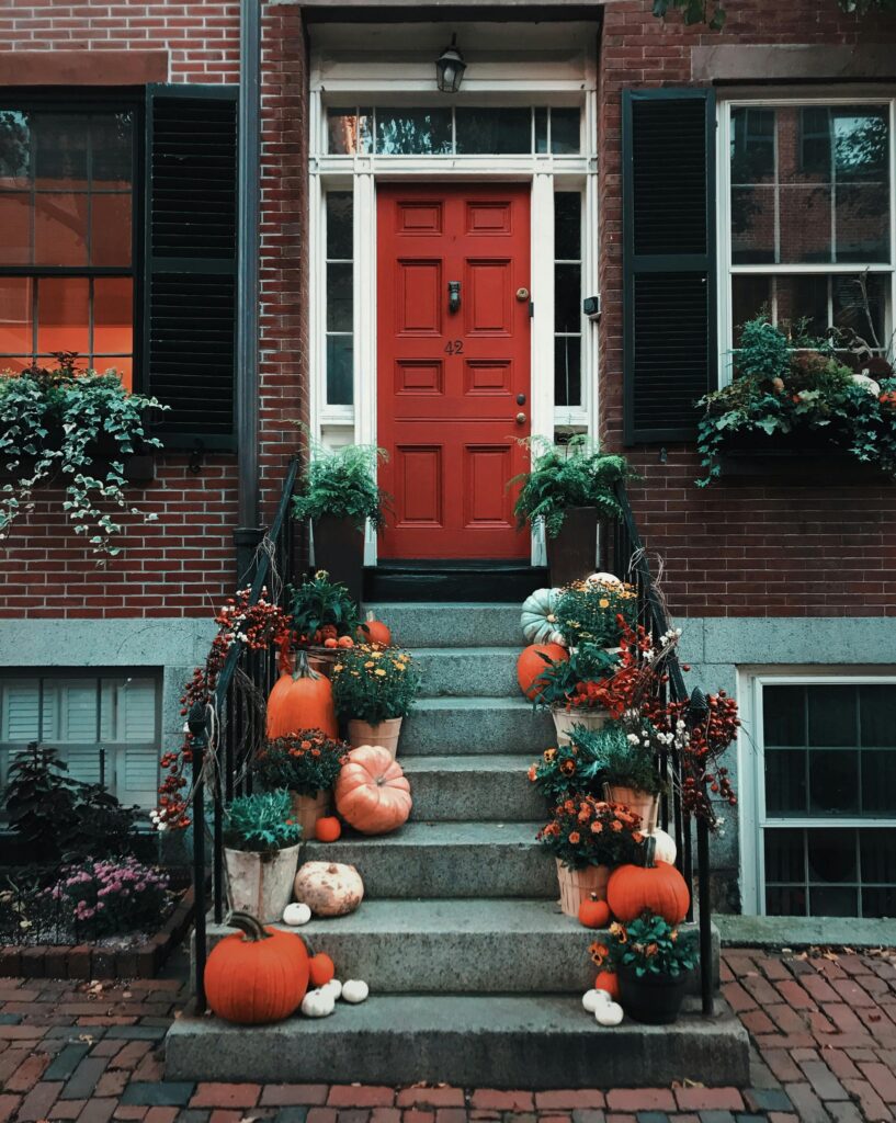 Festive autumn decorations with pumpkins and greenery on a Boston doorstep.