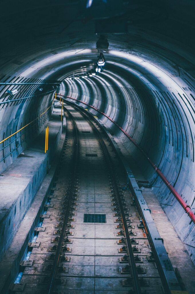 A moody subway tunnel with curved railway tracks creates depth and intrigue.