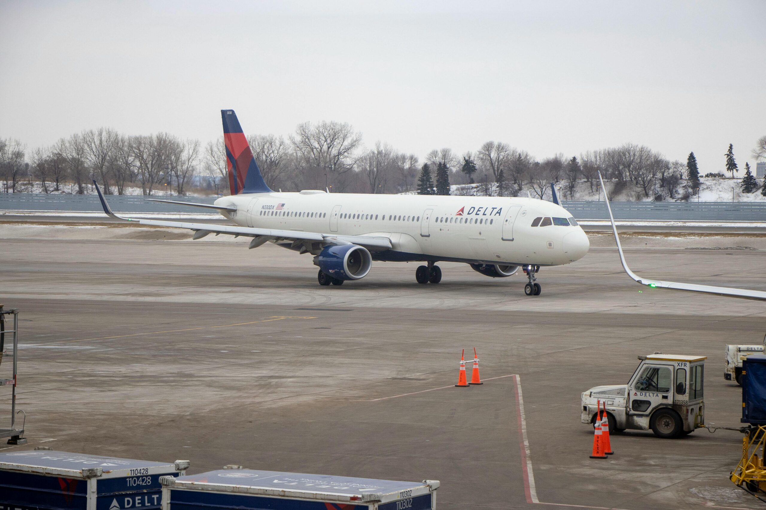 Delta airplane preparing for departure at a snowy Minnesota airport.