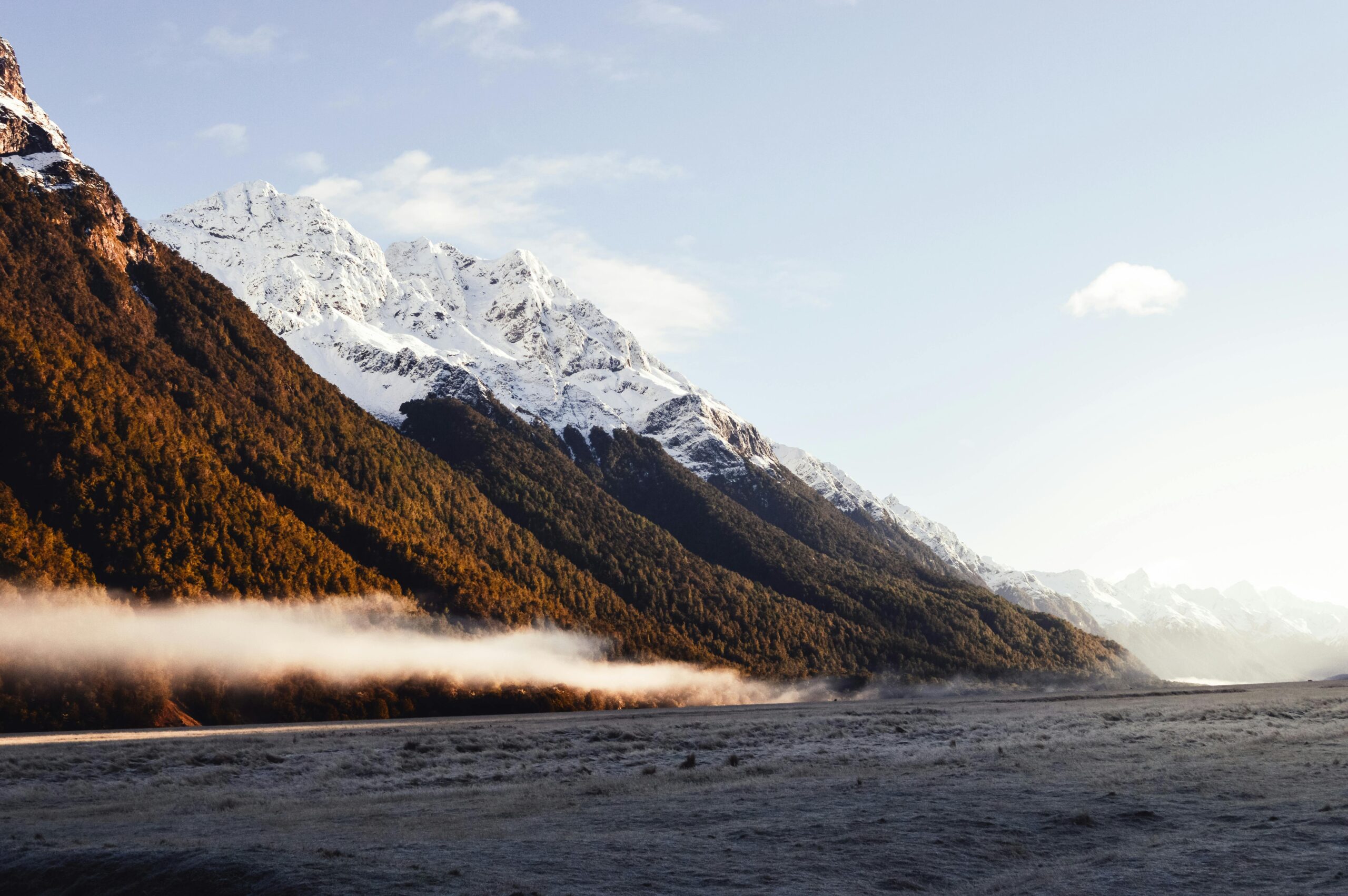 Breathtaking view of snow-capped mountains with mist in Queenstown, New Zealand.