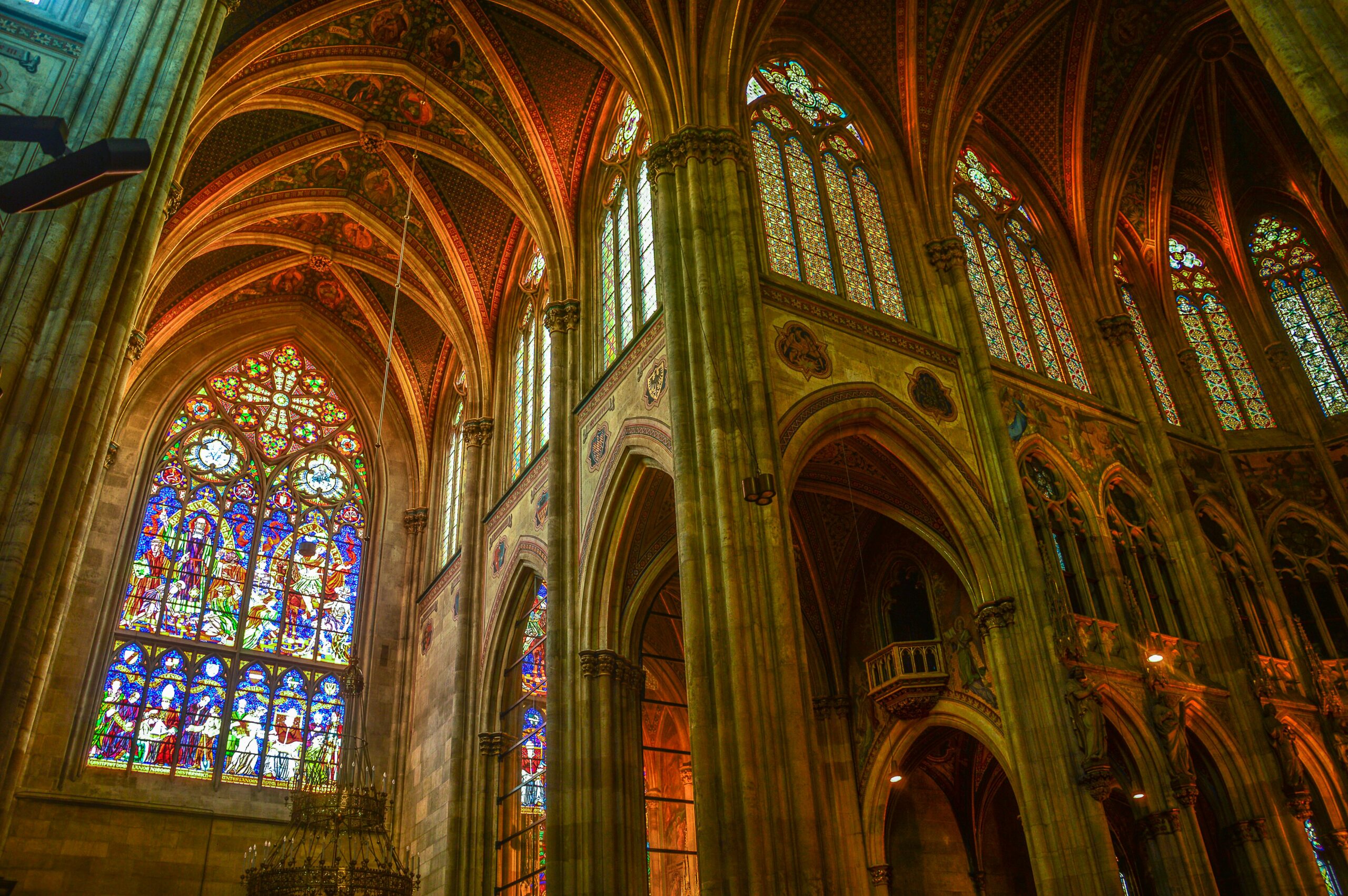 Beautiful medieval cathedral interior showcasing arched ceilings and vibrant stained glass windows.