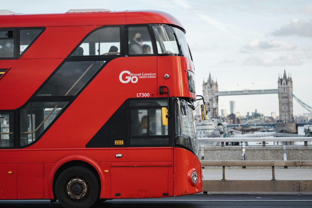 Modern bus driving along river against bridge