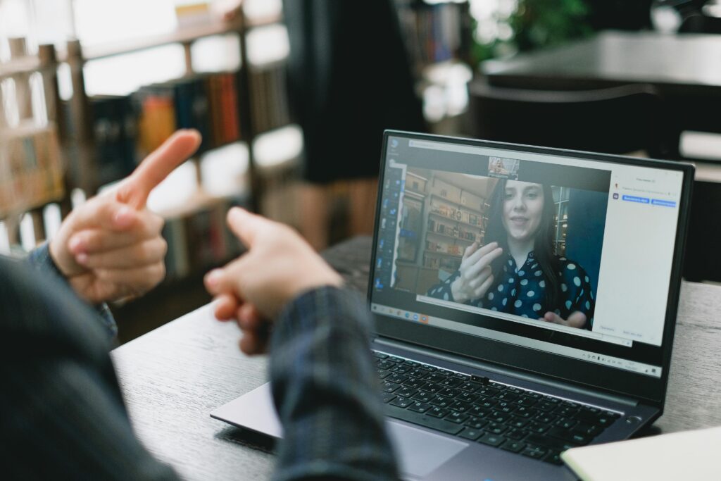 An online video call showcasing sign language communication between two individuals.