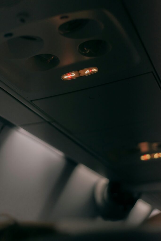 Close-up of an airplane cabin interior showing illuminated fasten seat belt sign.