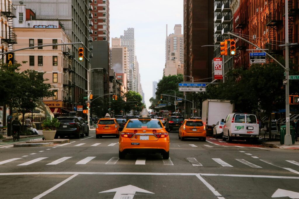 Vibrant city traffic with iconic New York taxis under traffic lights.