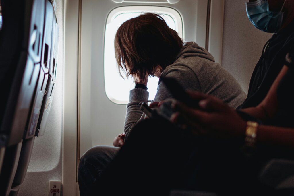 A passenger gazes out of an airplane window, reflecting on in-flight travel.