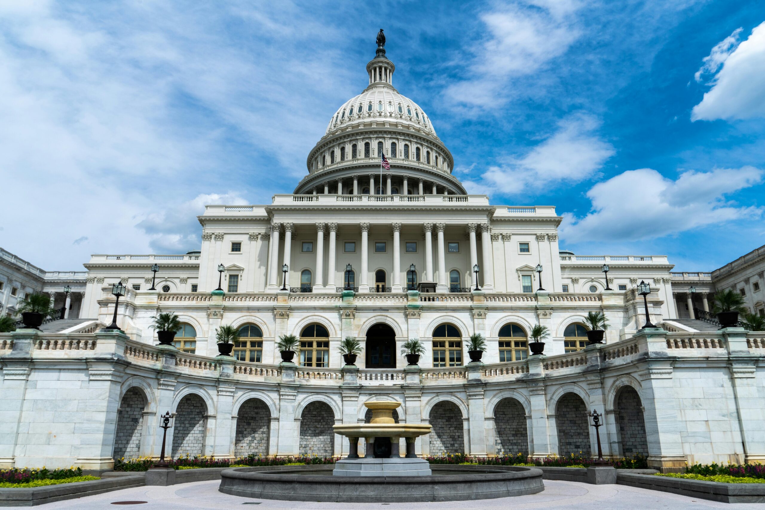 Exterior view of the iconic US Capitol Building on a sunny day in Washington, DC.