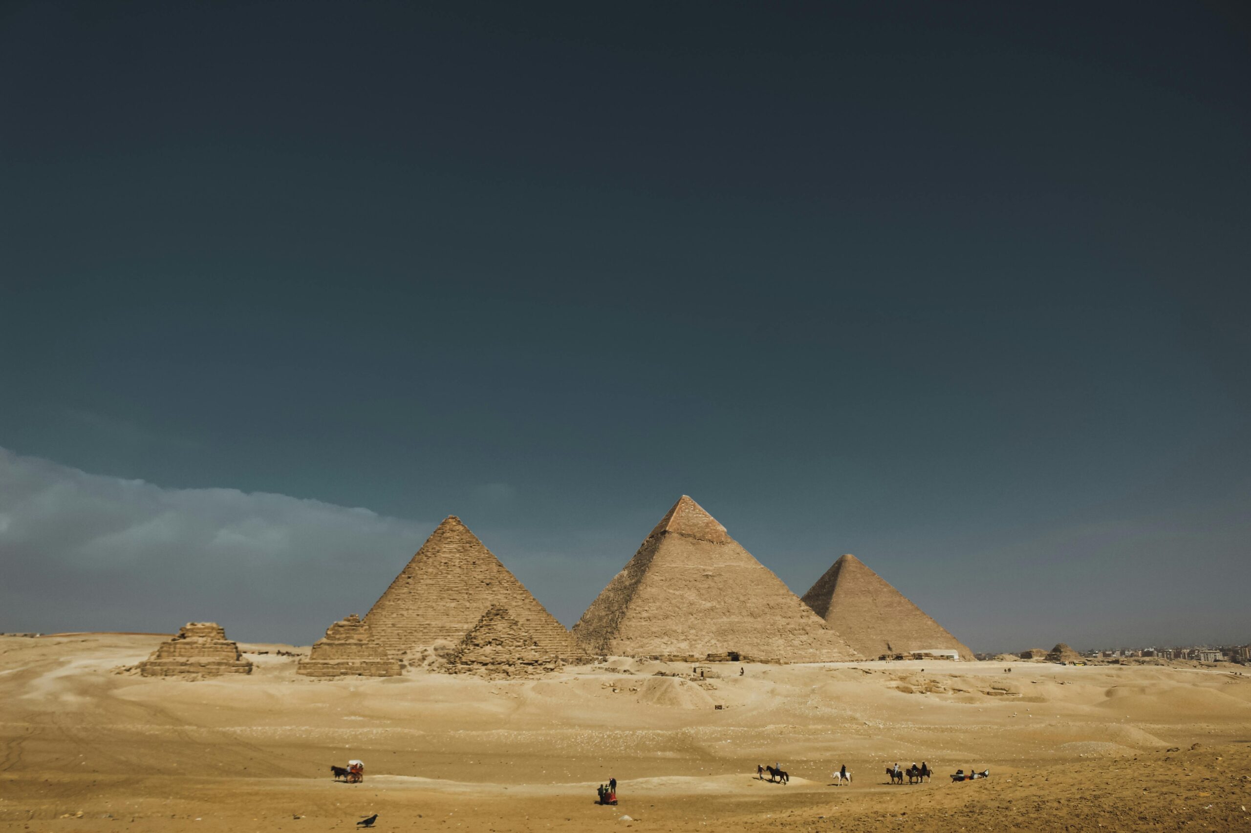 Explore the iconic Pyramids of Giza in Egypt, captured under a wide desert sky.