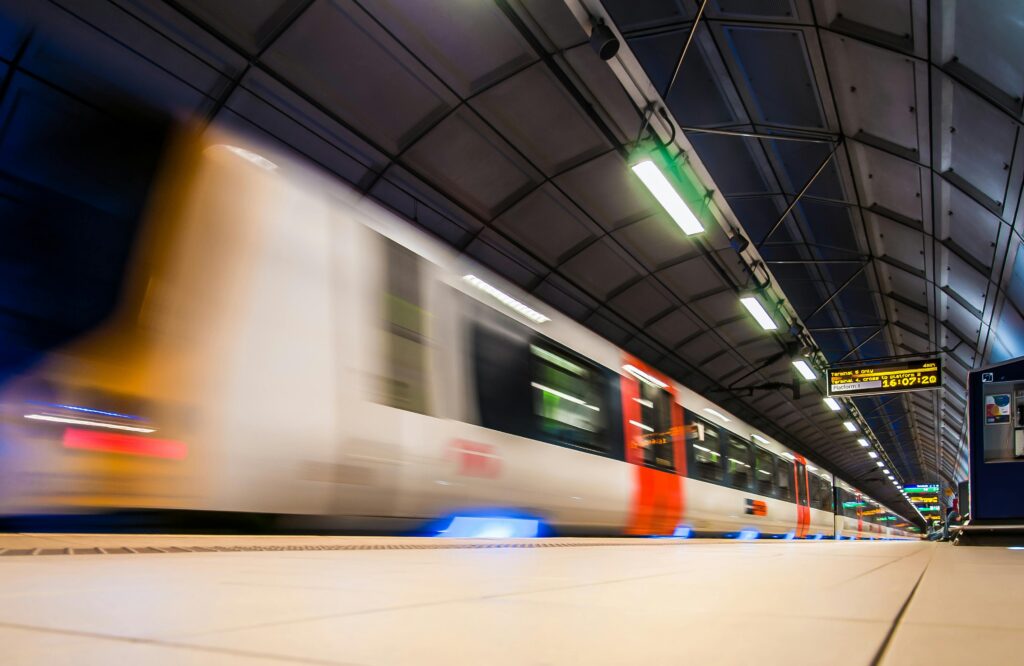 Blurred image of a train rushing through an indoor subway station in Longford, UK.