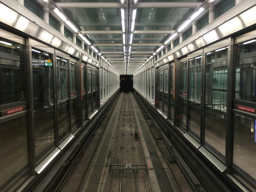 A modern, symmetrical train tunnel in a Washington DC airport terminal, showcasing transportation architecture.