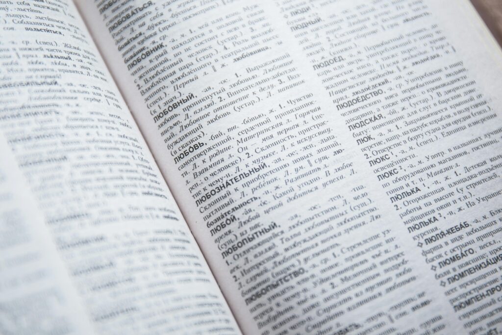 Close-up view of an open Russian dictionary showing detailed text and entries.