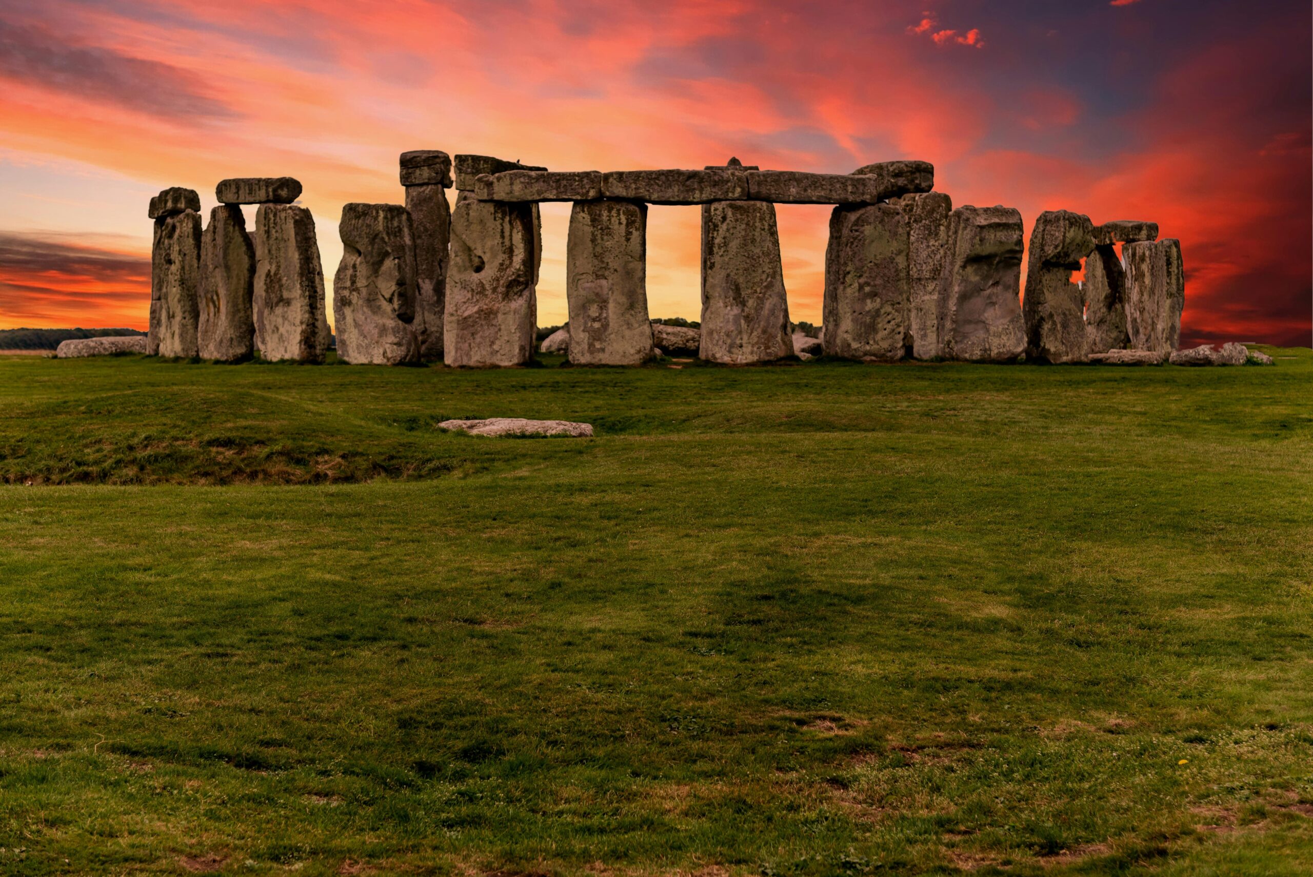 Capture of the iconic Stonehenge during a vibrant sunset with a dramatic sky.