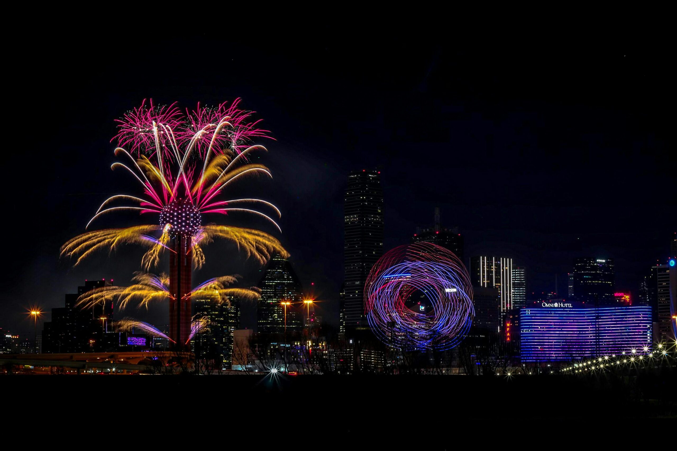 Vibrant fireworks display over the Dallas skyline, capturing the New Year's Eve celebration at night.