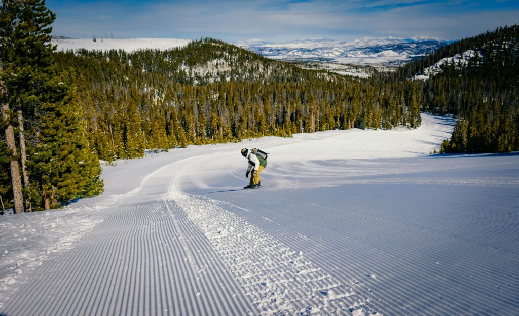 A person skiing down a snowy slope with a backpack