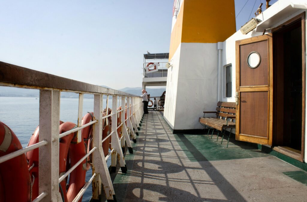 A serene view from a ferry deck in Yalova, Türkiye, showcasing railings and the sea.