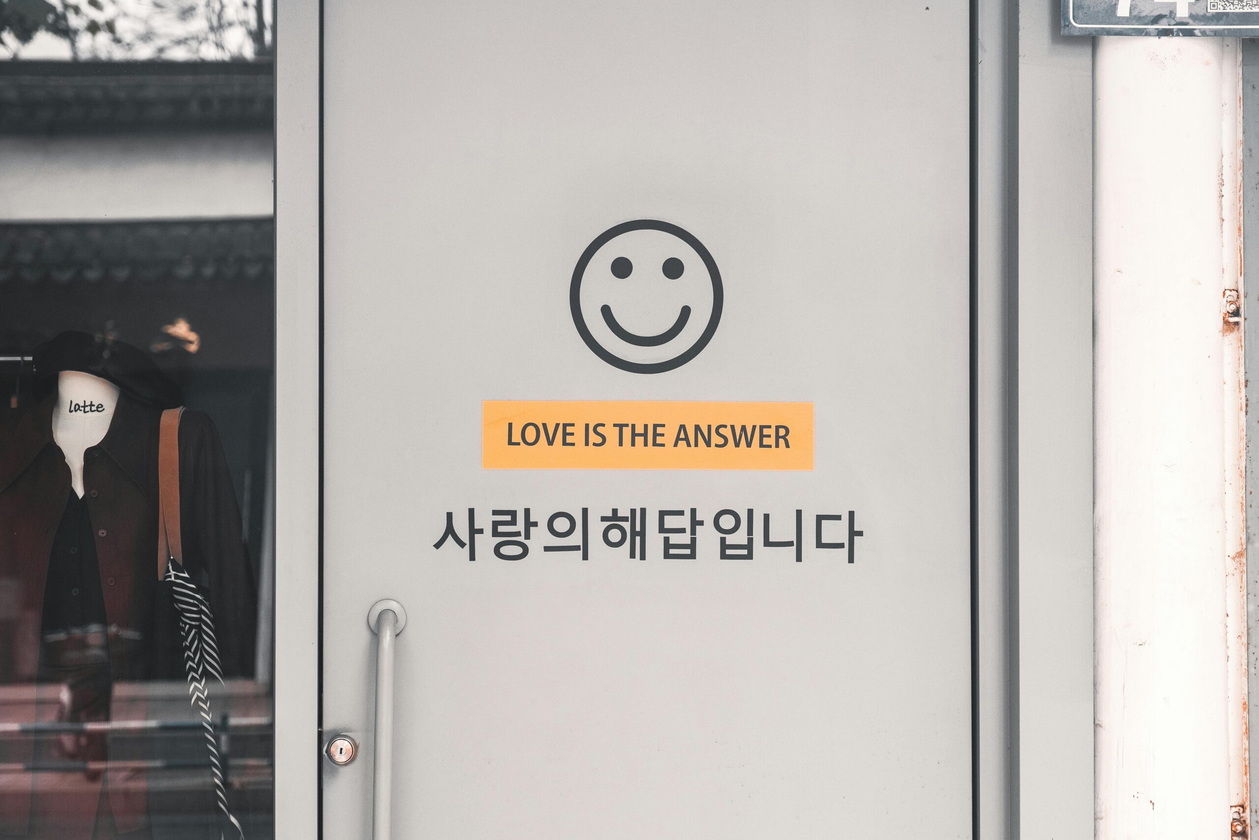 Grey door with a smiley face and 'Love is the Answer' text in English and Korean.