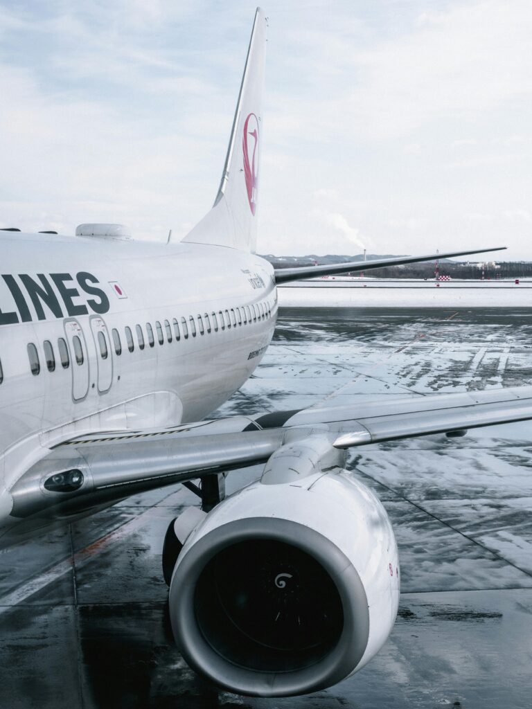 Close-up of an airliner on a wet runway after rain with reflections on the tarmac.