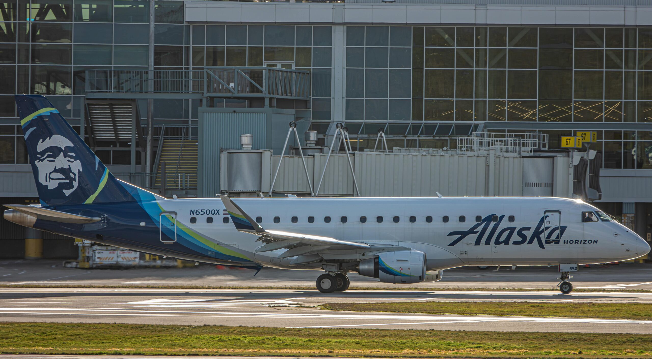 Alaska Horizon airplane ready for departure at a bustling airport.