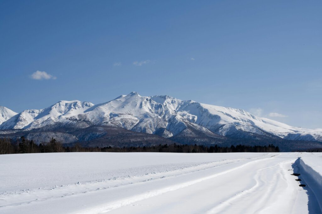 Snow-covered mountains and serene landscape in Sounkyo Onsen, Hokkaido, Japan.