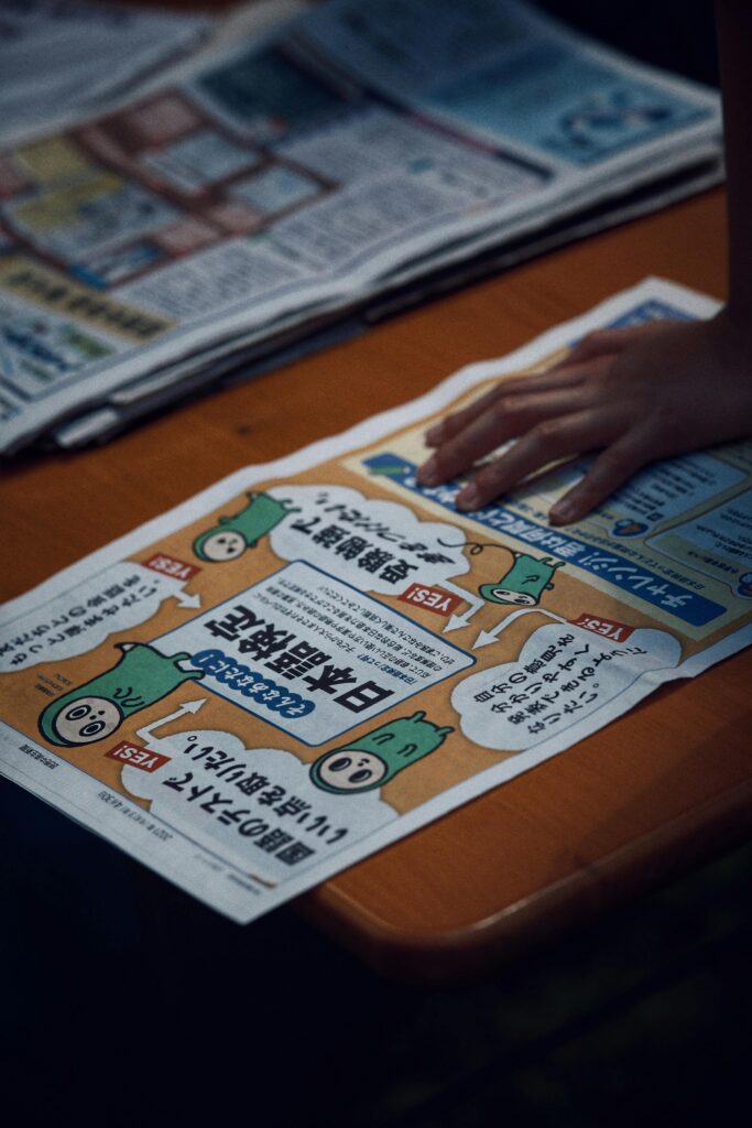 A newspaper page featuring eye-catching graphics and text, held by a hand.