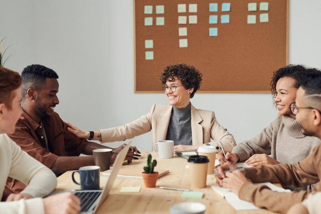 Business professionals engaged in a collaborative meeting in a modern office setting, sharing ideas and smiling.