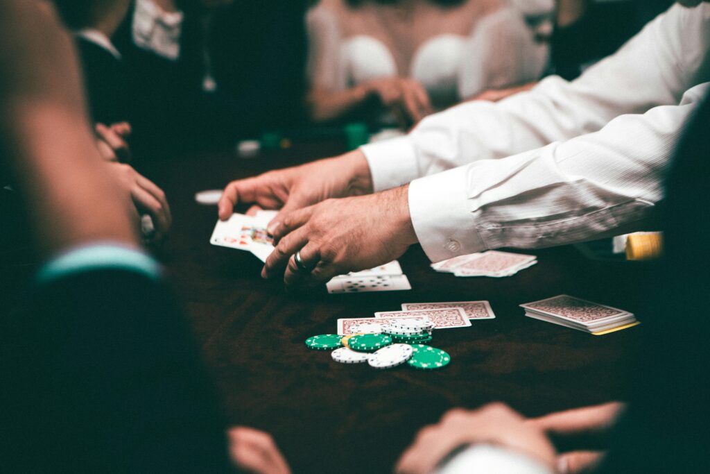 An intense poker game featuring players and poker chips on the table in an indoor setting.