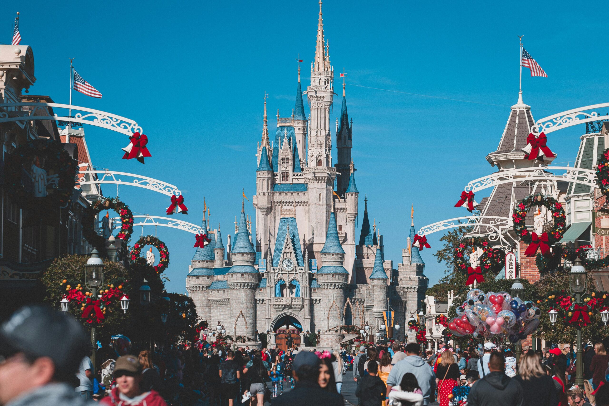 A busy day at Orlando's Magic Kingdom with crowds enjoying holiday decorations.