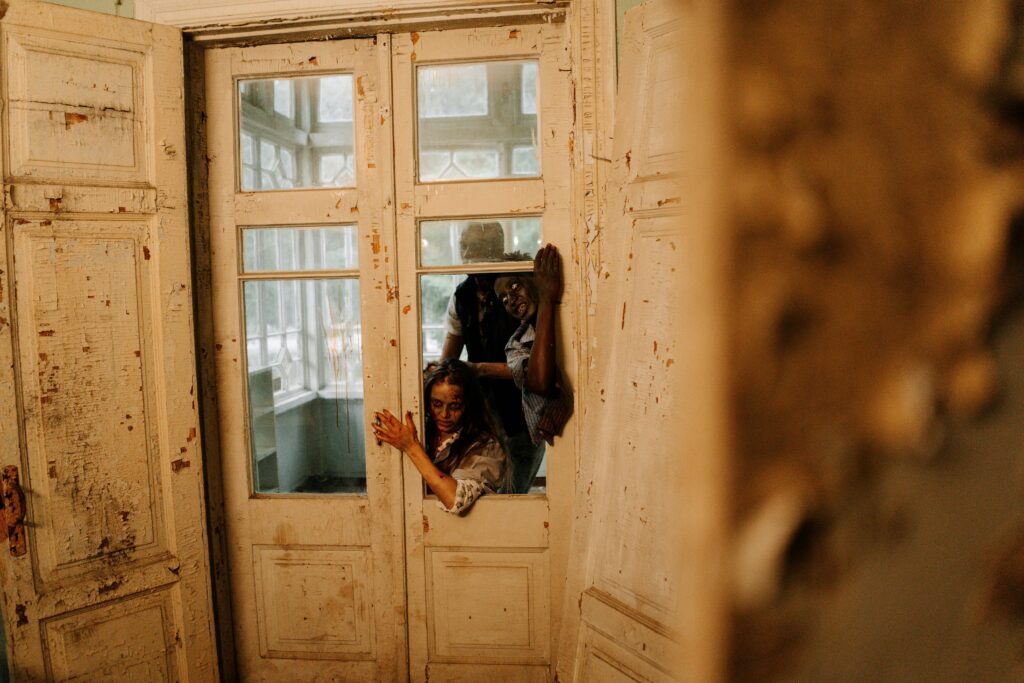 Spooky horror scene with zombies breaking through an old wooden door, perfect for Halloween themes.