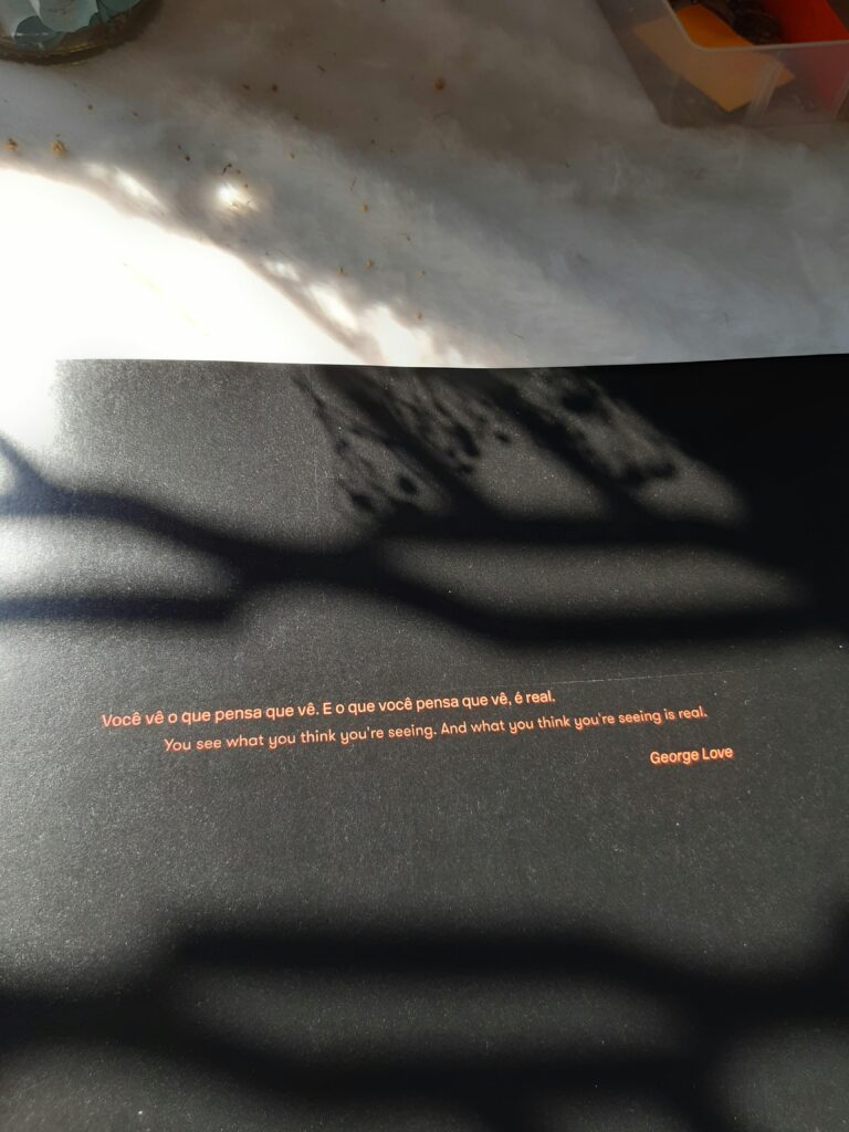 Shadow play over a motivational quote by George Love on a black surface.