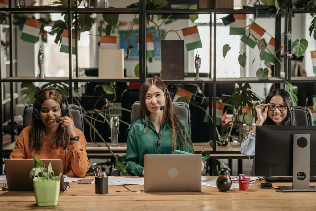 A multicultural group of women working in a modern office setting, showcasing teamwork.