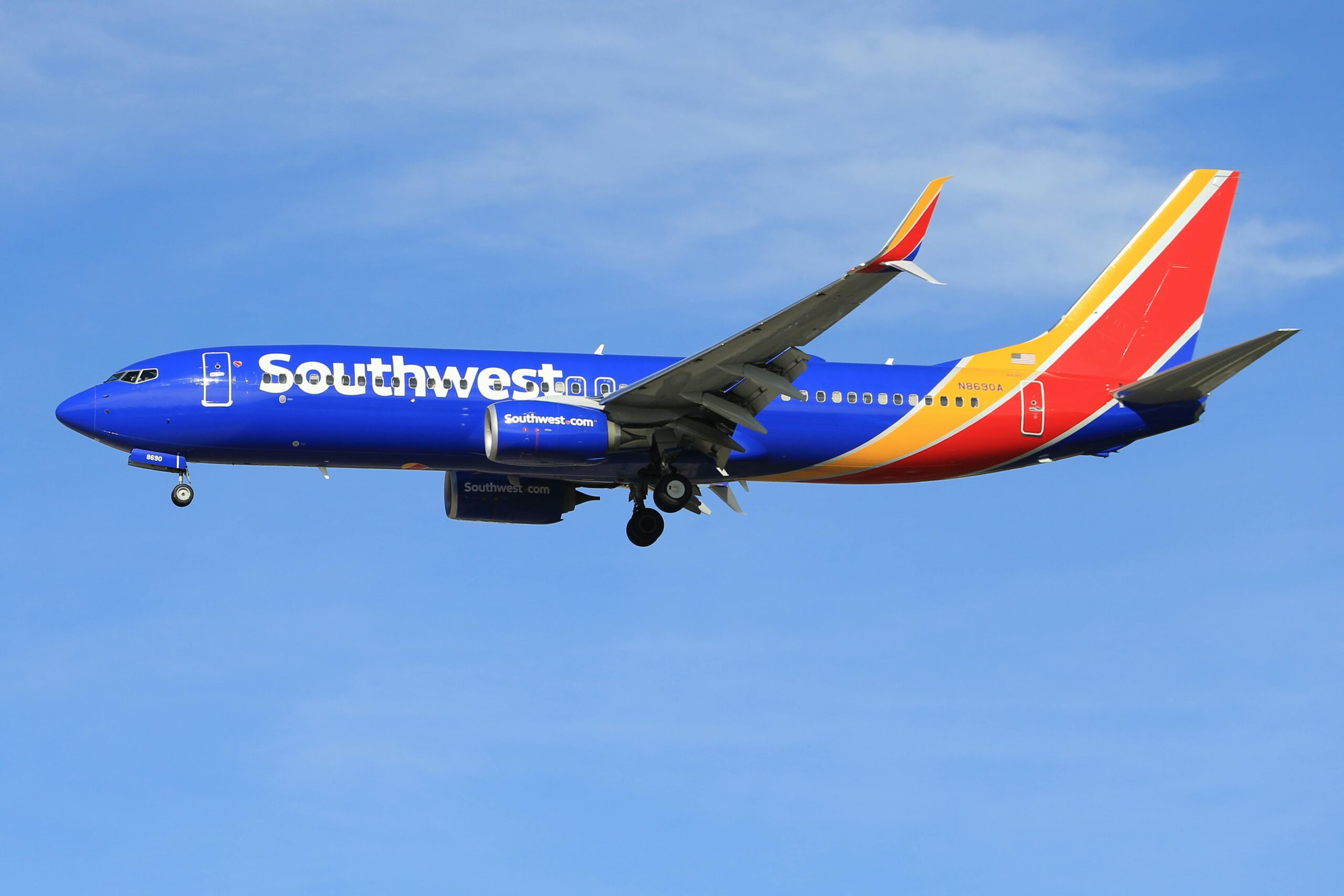 A vibrant Southwest Airlines airplane flying against a clear blue sky, showcasing its colorful livery.