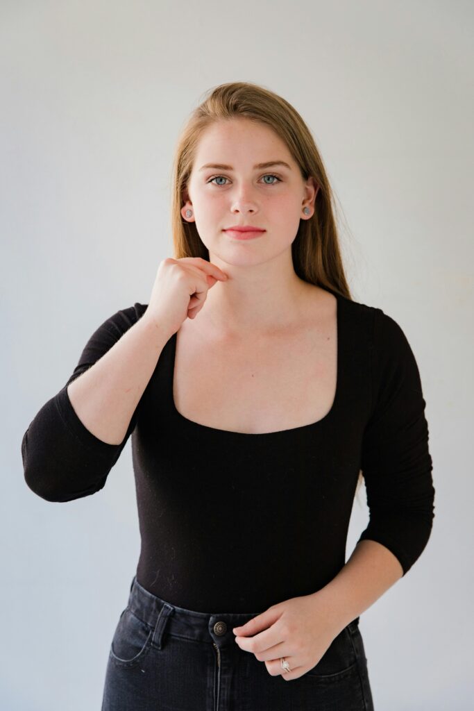 Portrait of a Caucasian woman using sign language on a white background.