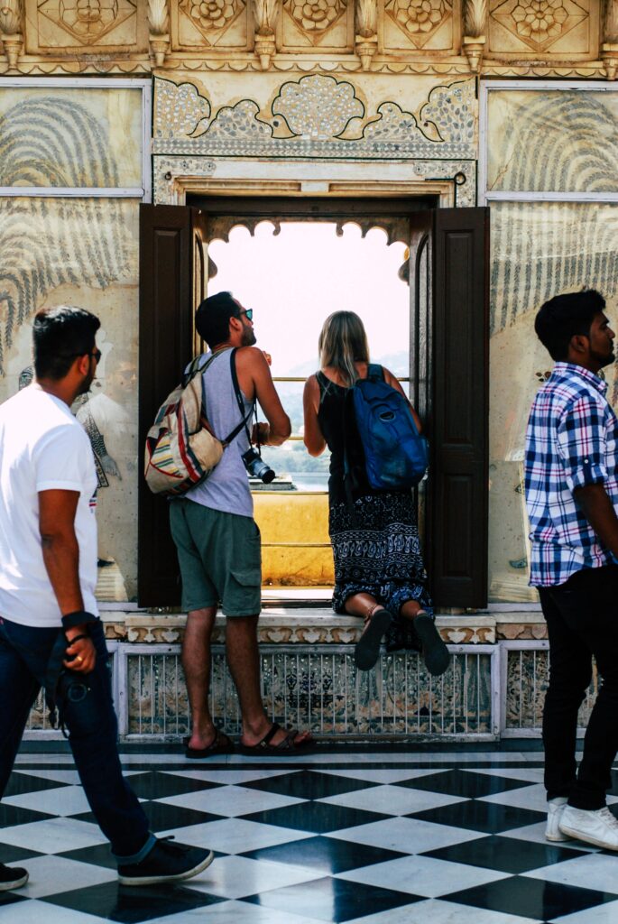 Tourists admire the historic architecture and scenic views from a palace in Udaipur, India.