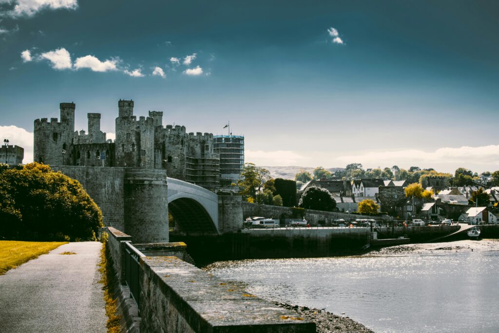 A captivating shot of the historic Conwy Castle and bridge under a vibrant sky in Wales.