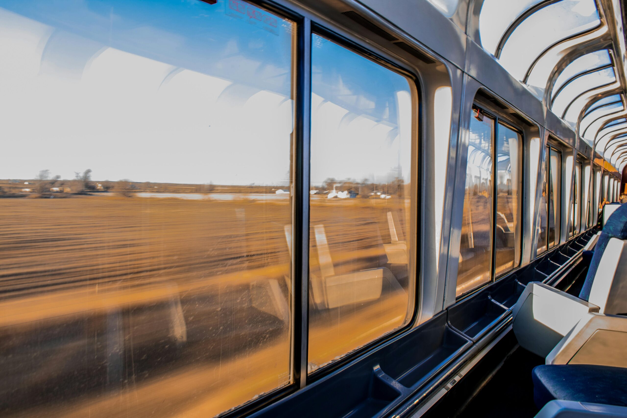 Interior of a modern train traveling at high speed with a scenic landscape view through large windows