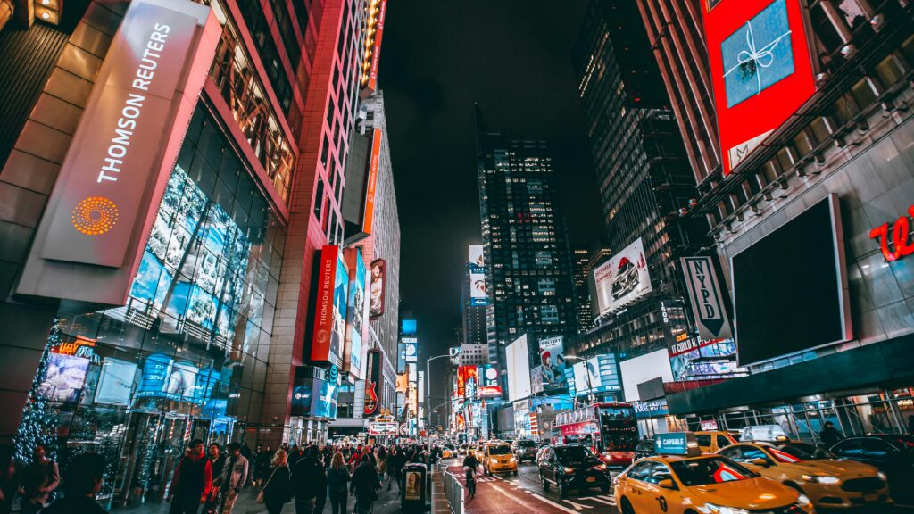 Bustling evening scene in New York City's iconic Times Square, showcasing bright lights and lively atmosphere.