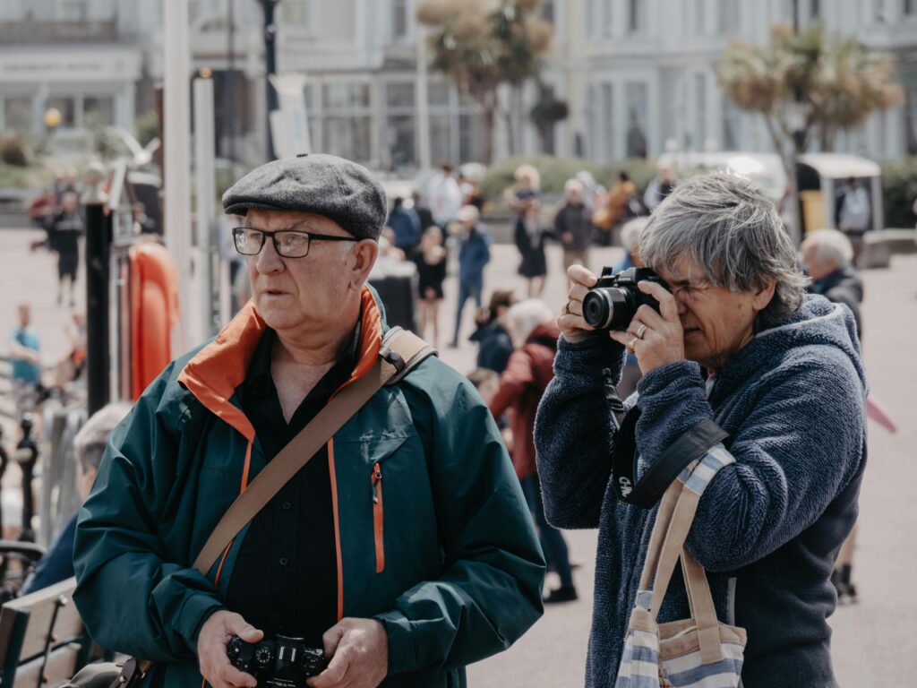 Senior tourists capturing moments at a UK landmark, embracing travel and leisure.