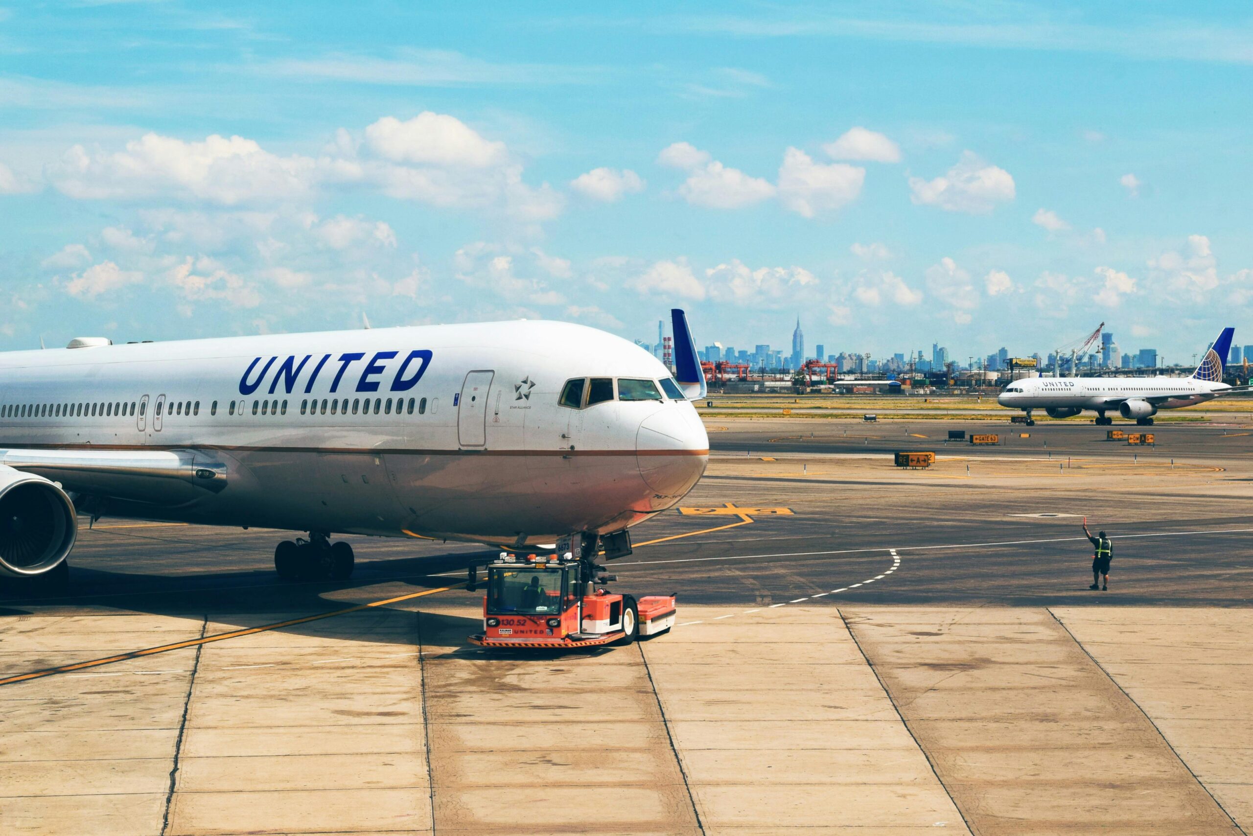 Aircraft on the runway at Newark Airport with city skyline in the background.