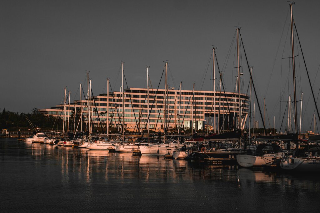 Gamagōri marina at sunset with moored yachts and hotel backdrop reflecting serene water views.