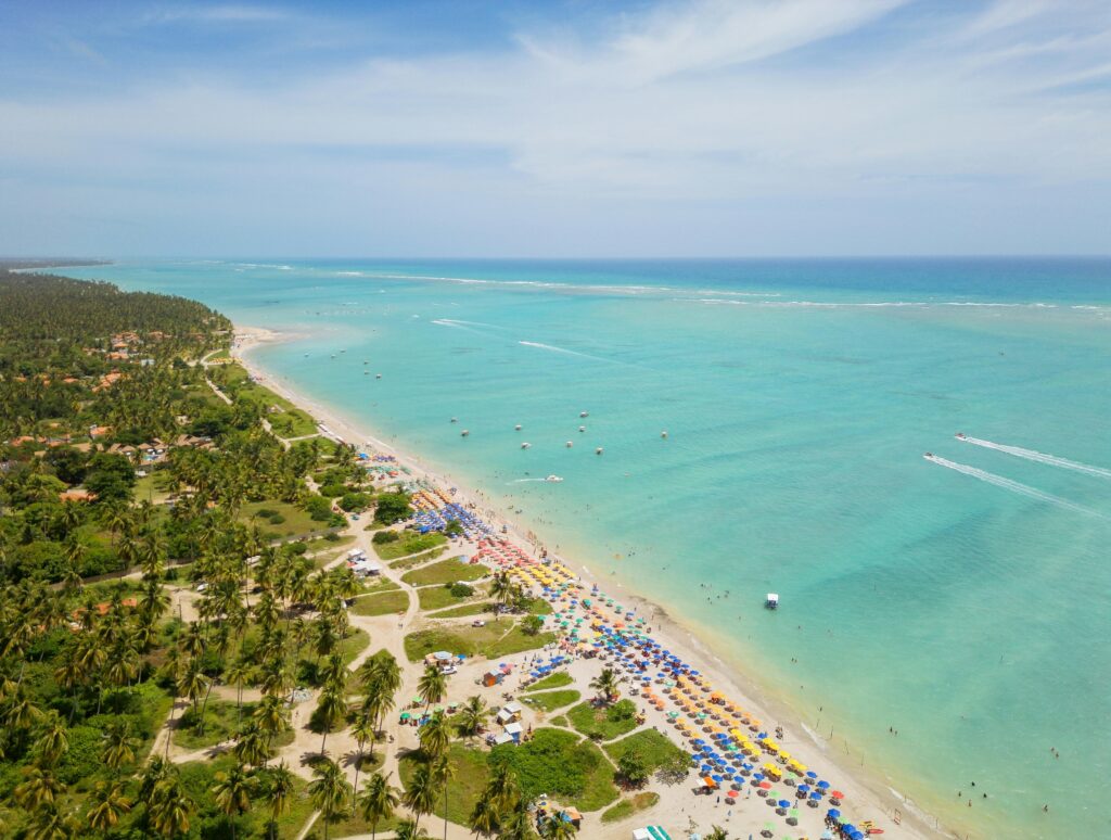 Stunning aerial view of Antunes Beach, Brazil with turquoise waters and vibrant umbrellas.