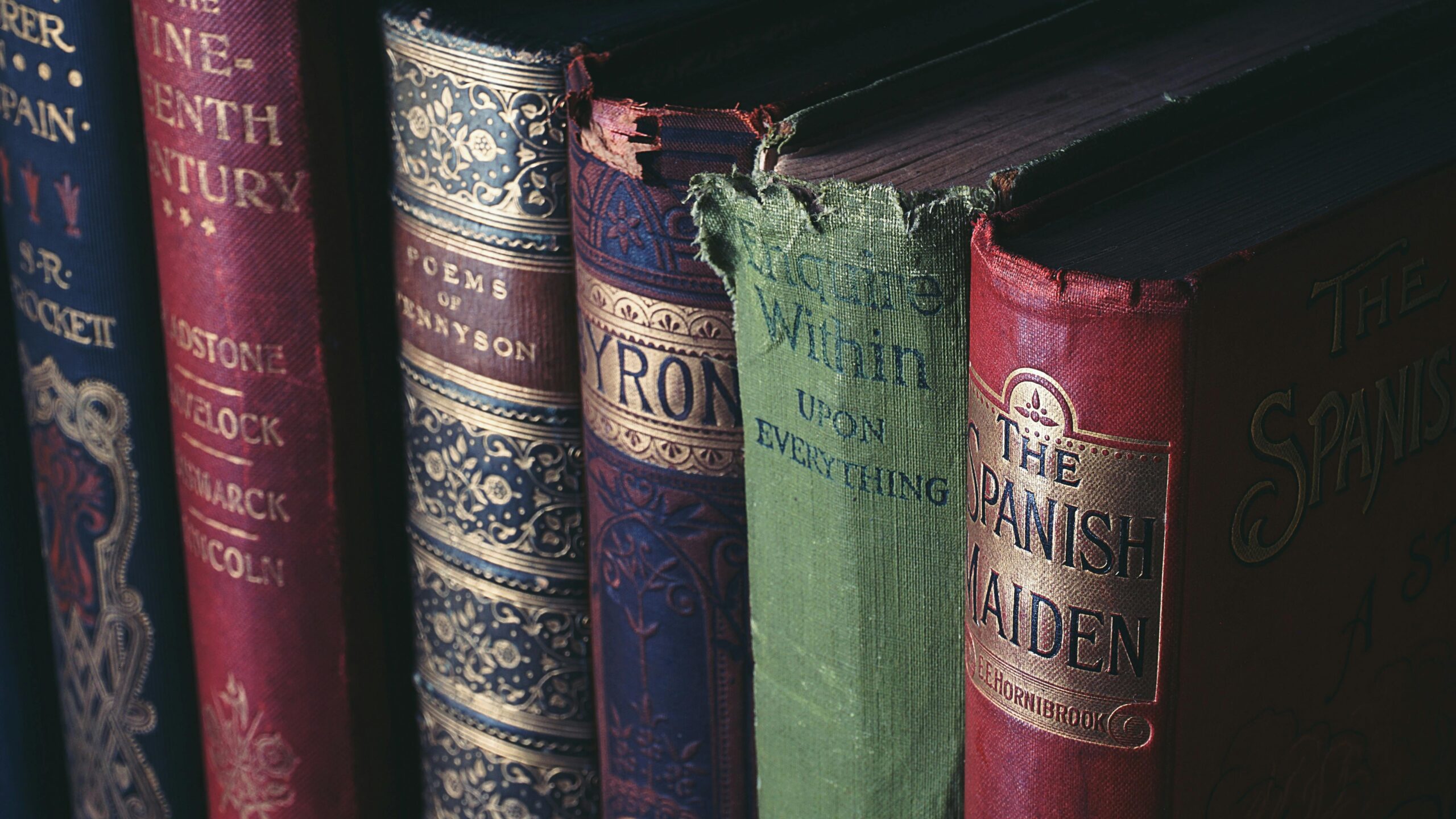 Close-up of vintage hardcover books showcasing ornate book jackets and titles.